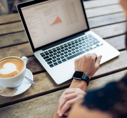 Przedsiębiorca analizujący ofertę energii na laptopie w kawiarni