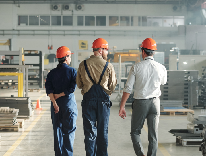 zdjęcie audytorów energetycznych w kaskach na hali produkcyjnej 