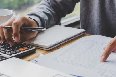 mężczyzna liczący na kalkulatorze